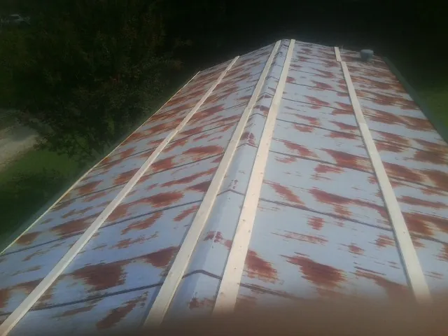 Rusted metal roof panels with new wood purlins before replacement — Storm Damage Roof Repair in Longview by Roofing Brothers