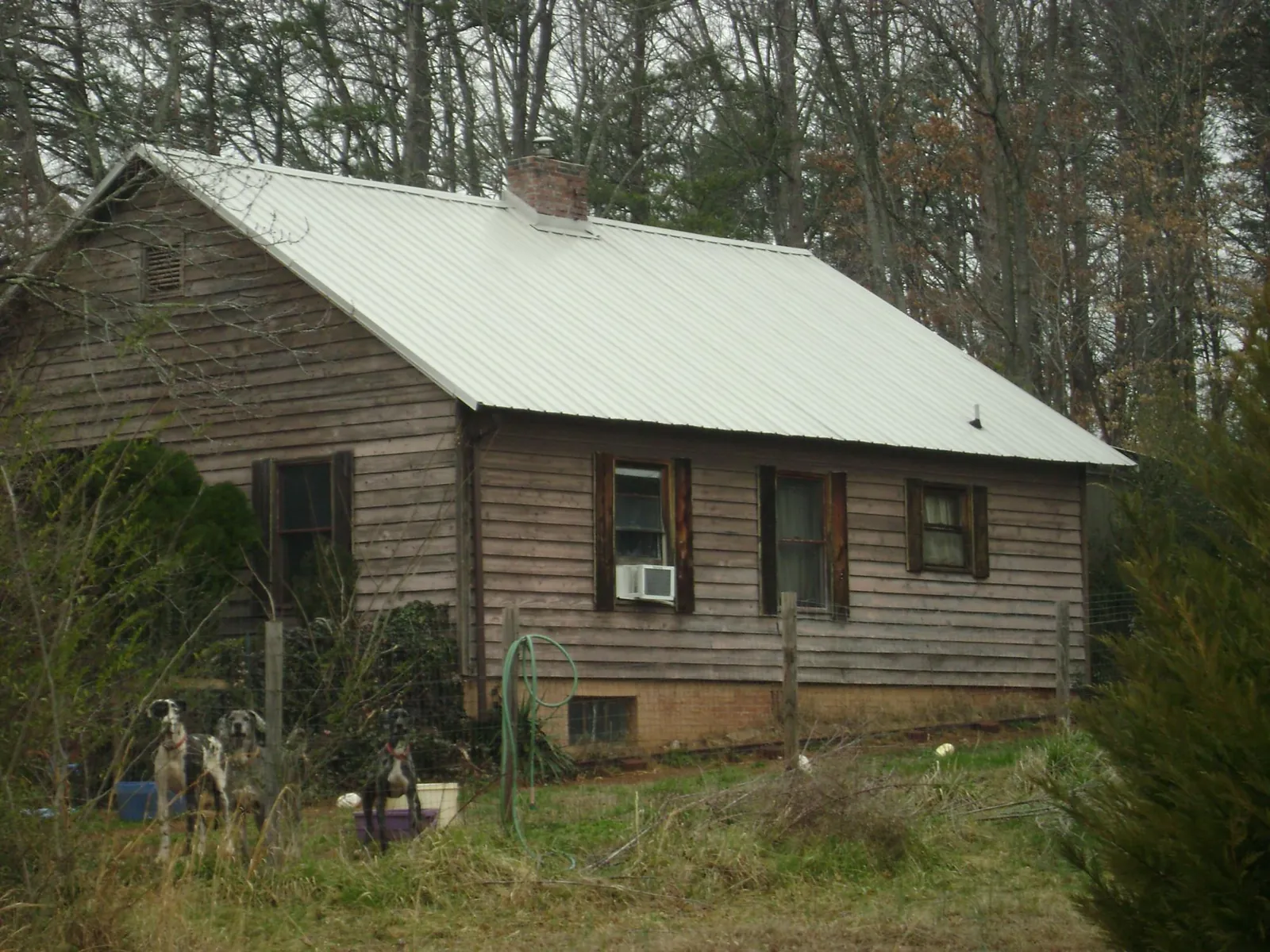 White metal roof on an old wood sided farmhouse, from a Metal Roof Installation job in Longview